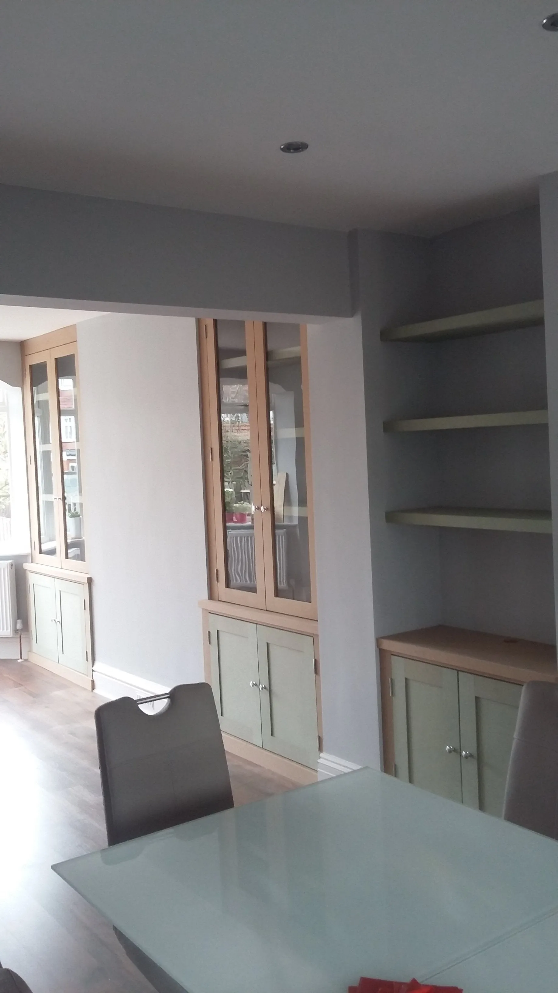 Cabinets with floating shelves and glass doors.